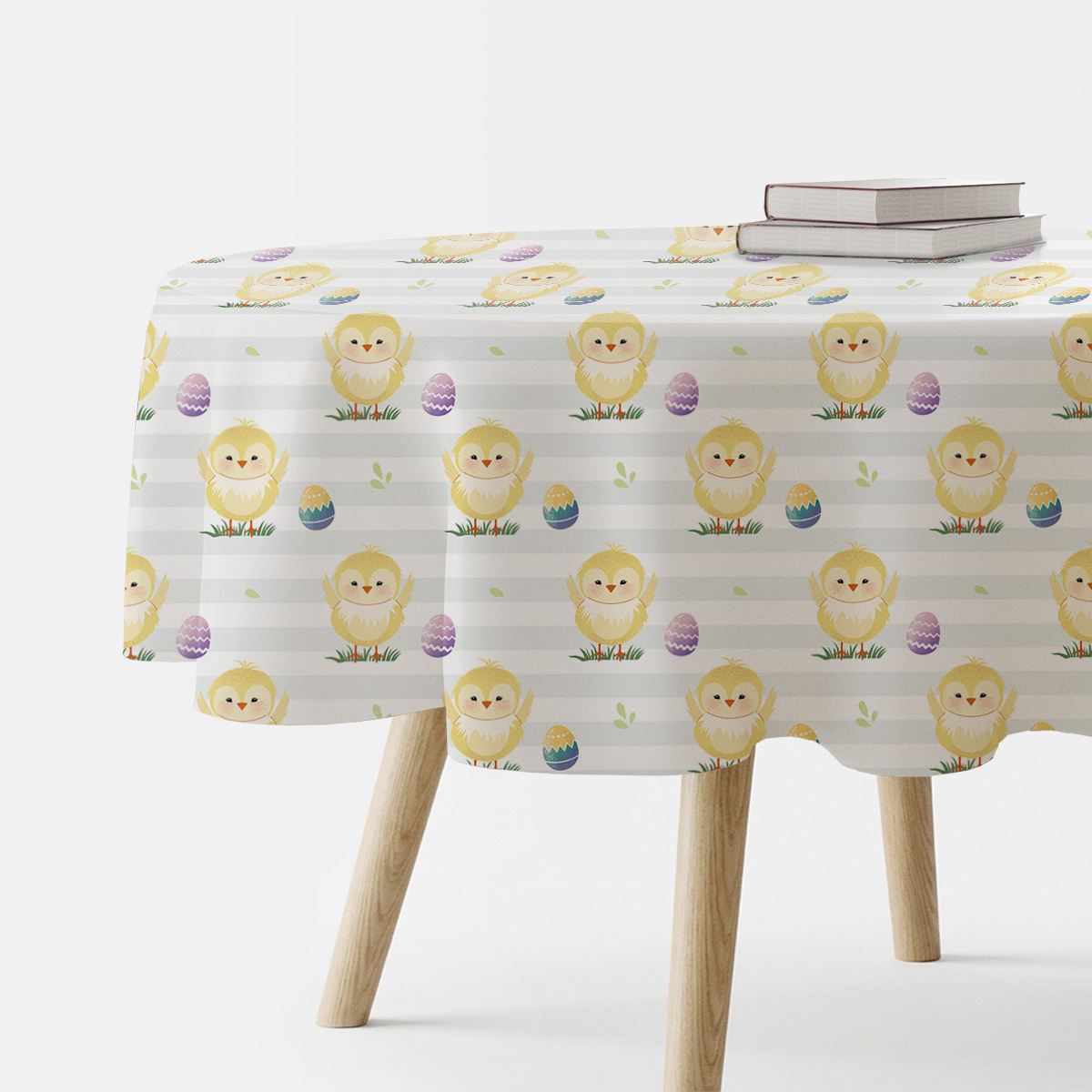 Okrągły obrus z motywem wielkanocnych kurczaczków i pisanek na stole, ujęcie z boku