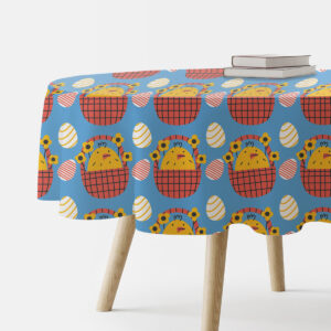 Główne ujęcie okrągłego stołu z obrusem w niebieskim kolorze ozdobionym kurczaczkami w koszykach i pisankami