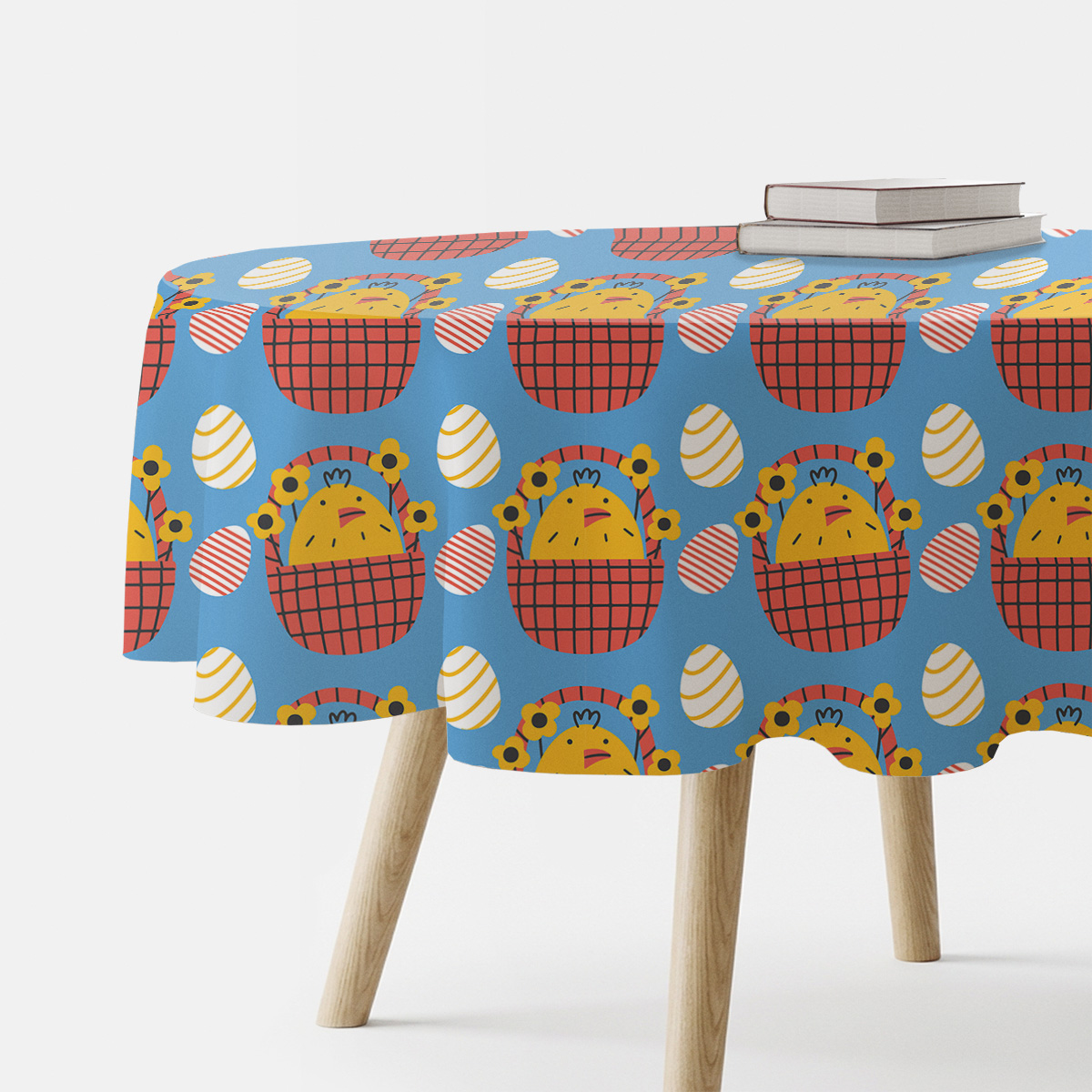 Główne ujęcie okrągłego stołu z obrusem w niebieskim kolorze ozdobionym kurczaczkami w koszykach i pisankami
