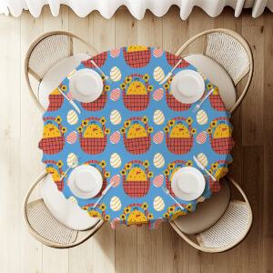 Widok z góry na okrągły stół udekorowany obrusem z kurczaczkami i wielkanocnymi pisankami