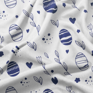 Zbliżenie na fakturę tkaniny i granatowe motywy pisanek oraz drobne elementy dekoracyjne