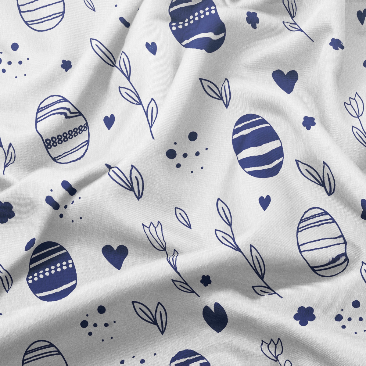 Zbliżenie na fakturę tkaniny i granatowe motywy pisanek oraz drobne elementy dekoracyjne