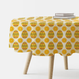 okrągły obrus z motywem wielkanocnych pisanek i słoneczek na stole, z dwoma książkami u krawędzi