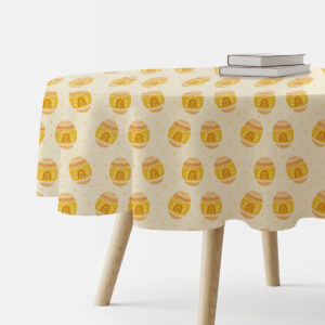 Okrągły stół nakryty obrusem z wzorem żółtych pisanek na kremowym tle, widok z boku
