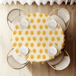 Widok z góry na okrągły stół z obrusem i ustawionymi talerzami, podkreślający regularny wzór pisanek