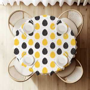 Widok z góry na okrągły stół udekorowany obrusem z motywem pisanek i ustawioną zastawą