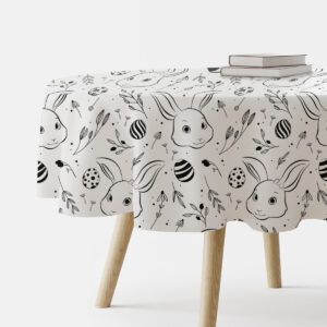 okrągły obrus z motywem króliczków i pisanek na stole widziany z boku z książkami na blacie