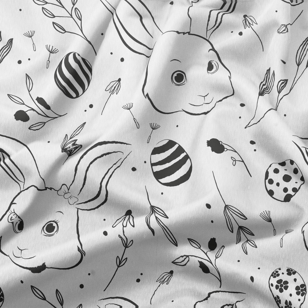 zbliżenie na detal nadruku z króliczą głową, pisankami i drobnymi gałązkami na materiale