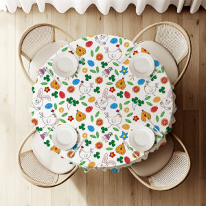 Widok z góry na okrągły stół nakryty obrusm z króliczkami, pisankami i ustawionymi talerzami