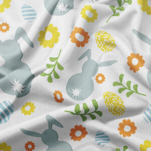 zbliżenie wzoru na tkaninie z sylwetkami zajączków, kolorowymi pisankami i kwiatami