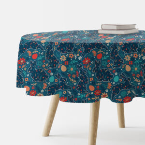 Okrągły obrus z wzorem zajączków i kwiatów na granatowym tle, widok fragmentu stołu z książkami