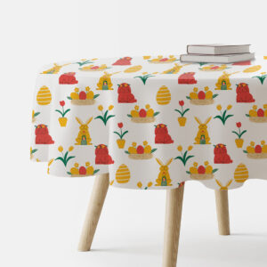 okrągły stół nakryty obrusem z motywem wielkanocnym: zajączki i pisanki na białym tle