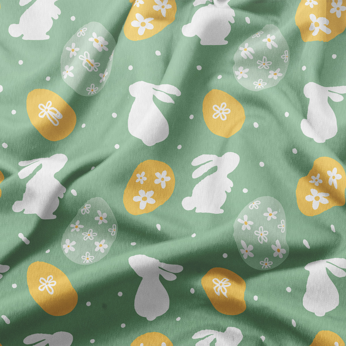 Zbliżenie na wzór przedstawiający sylwetki zajączków, ozdobne pisanki i drobne kropki na zielonym materiale