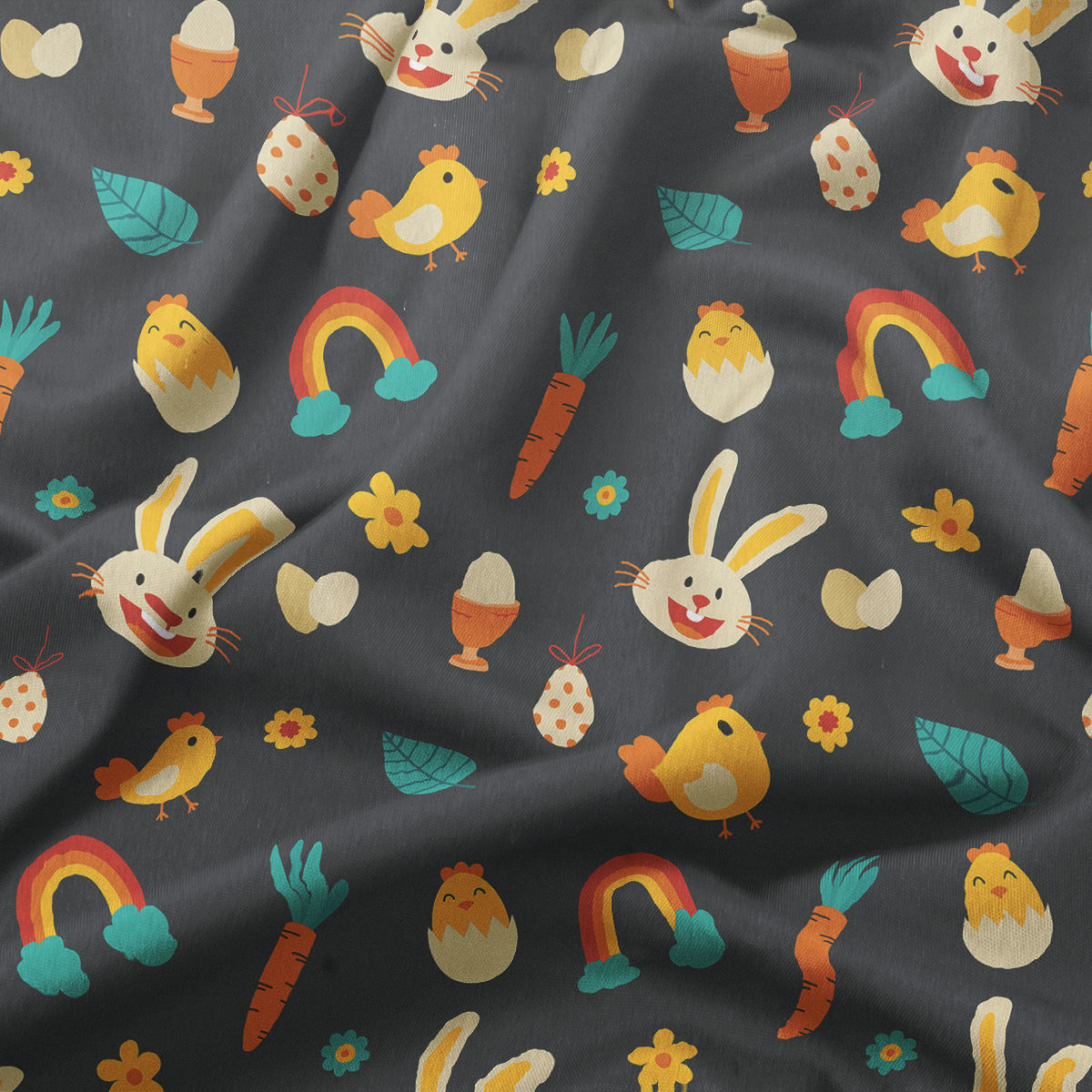 Zbliżenie na fakturę tkaniny i kolorowe ilustracje piskląt, jajek, marchewek oraz tęczy