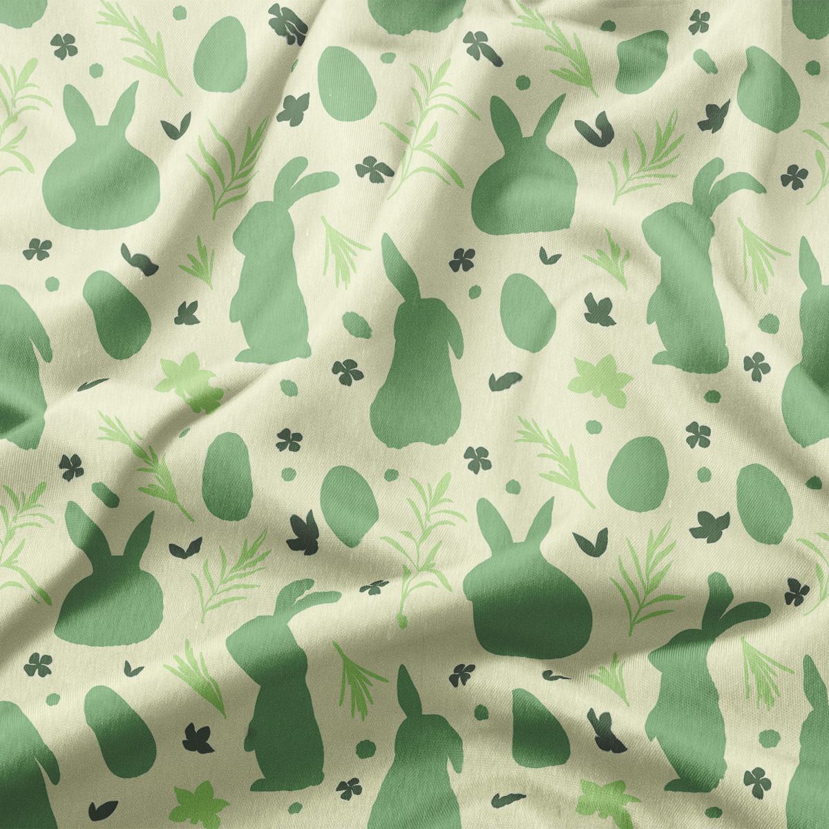 Zbliżenie tkaniny pokazujące rozmieszczenie zajączków, pisanek i delikatnych gałązek w różnych odcieniach zieleni