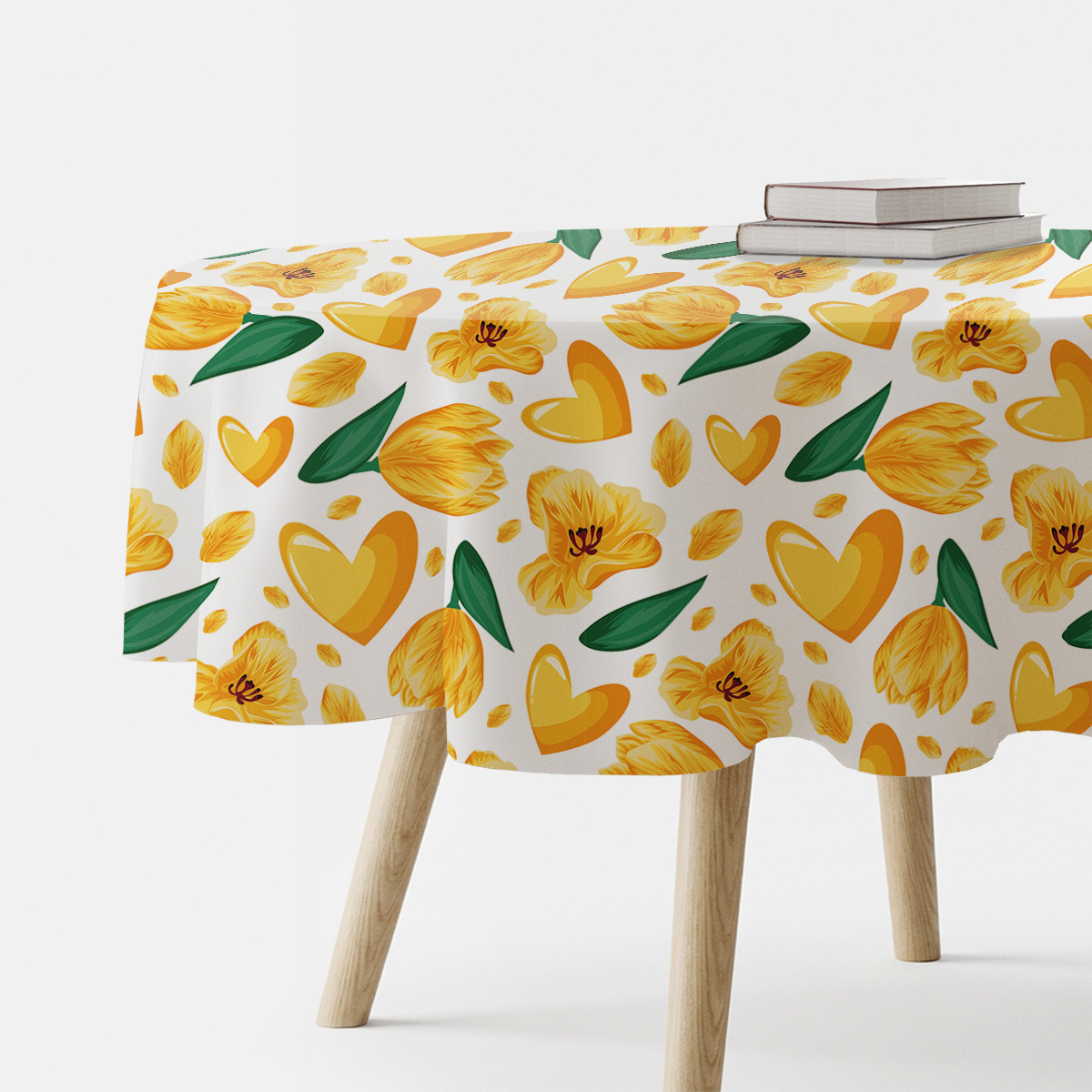 Główne ujęcie okrągłego obrusa z motywem żółtych tulipanów i serc rozłożonego na stole