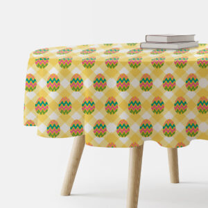 Okrągły obrus w żółtą kratę z kolorowymi pisankami, widok z boku na nakryty stół