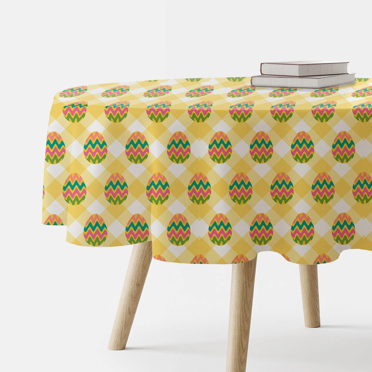 Okrągły obrus w żółtą kratę z kolorowymi pisankami, widok z boku na nakryty stół
