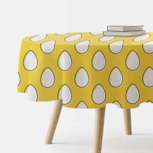 okrągły żółty obrus z białymi pisankami na stole widok z boku