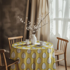 aranżacja stolika z białym dzbankiem i gałązkami na żółtym obrusie z pisankami