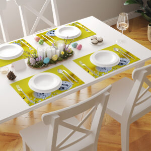 stół nakryty kilkoma żółtymi podkładkami z abstrakcyjnymi pisankami jako kompletny zestaw