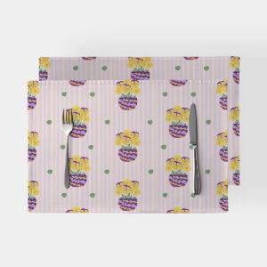 Dwie podkładki na stole z motywem pastelowych pasów i doniczek z żółtymi bratkami ułożone obok sztućców