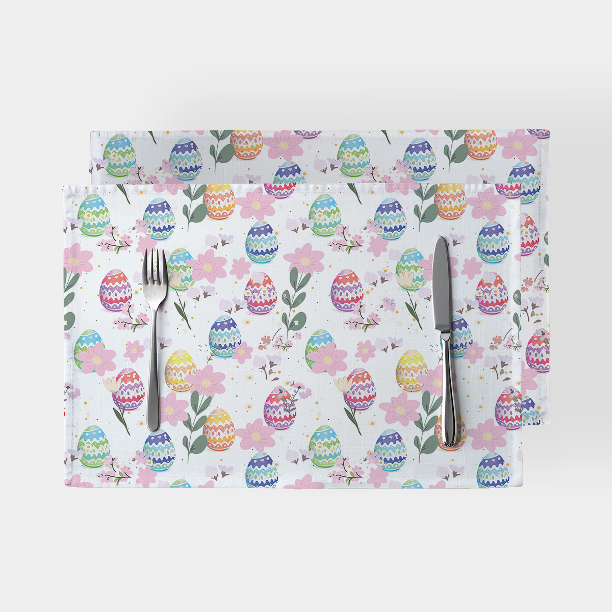 Komplet dwóch podkładek na stół z wzorem pastelowych pisanek i różowych kwiatów na jasnym tle