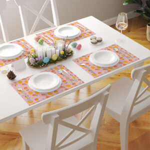 Stół nakryty kilkoma podkładkami w wiosennym wzorze podczas wielkanocnej aranżacji z zastawą