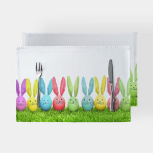 Główne ujęcie podkładki z rzędem pastelowych jajek z uszami króliczka na zielonej trawie z widocznymi sztućcami