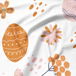 Zbliżenie na detal tkaniny i nadruku z pomarańczową pisanką, pastelowym kwiatem i rozproszonymi kropkami