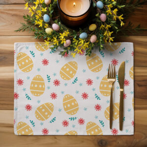Podkładka ustawiona na drewnianym stole obok świecy i wiosennej dekoracji z małymi jajkami