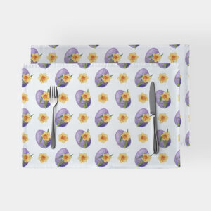 Główne ujęcie dwóch białych podkładek ze wzorem fioletowych pisanek i żółtych żonkili ułożonych z sztućcami