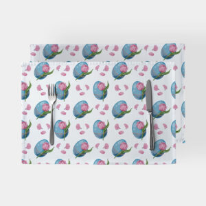Dwie podkładki z nadrukiem niebieskich pisanek i różowych tulipanów ułożone na białym stole ze sztućcami