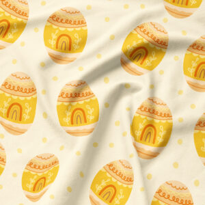 Zbliżenie na tkaninę z motywem żółtych pisanek i drobnymi kropeczkami pokazujące fakturę materiału