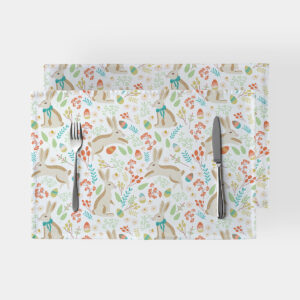 Dwie podkładki z motywem zajączków i pisanek ułożone jedna na drugiej z widocznym widelcem i nożem