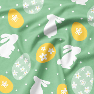 Zbliżenie na fakturę tkaniny i nadruk z białym zającem oraz żółtą pisanką ozdobioną kwiatuszkami