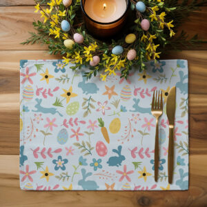 Podkładka ustawiona na drewnianym blacie z dekoracyjnym stroikiem i sztućcami ukazująca aranżację stołu