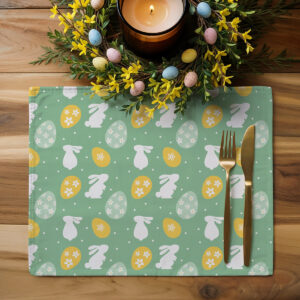Podkładka z motywem zajączków i pisanek ustawiona na drewnianym stole obok sztućców i wiosennej dekoracji