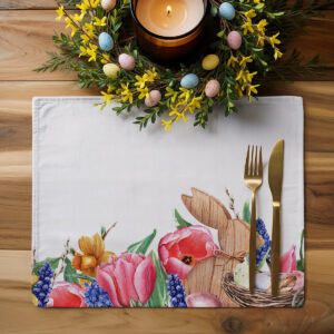 Aranżacja stołu z podkładką, złotymi sztućcami i wiosennym wieńcem z pisankami