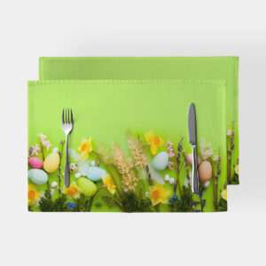 Para zielonych podkładek stołowych z motywem żonkili i kolorowych pisanek, ustawione z sztućcami