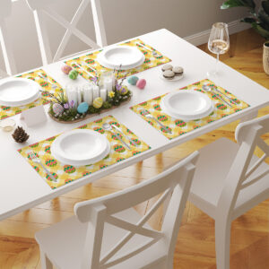 Jasny stół nakryty kilkoma podkładkami z żółtą kratą i pisankami w wiosennej aranżacji