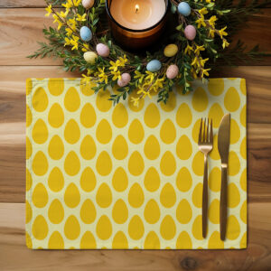 Podkładka z motywem żółtych pisanek ułożona na drewnianym stole z dekoracją wielkanocną i sztućcami
