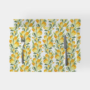 Dwie podkładki na stół z wzorem żółtych tulipanów na białym tle ułożone na blacie z sztućcami