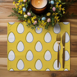 Podkładka ustawiona na drewnianym stole obok wiosennej dekoracji z pisanek i złotych sztućców