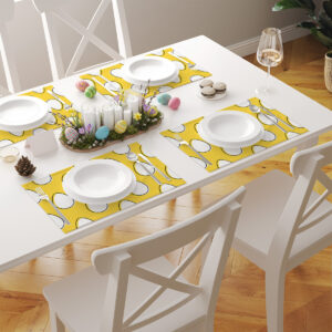 Nakryty stół z kilkoma żółtymi podkładkami z motywem pisanek w wielkanocnej aranżacji