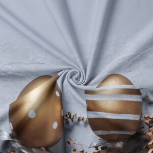 zbliżenie na detale nadruku: złote pisanki i papierowe wiórki na fakturze tkaniny