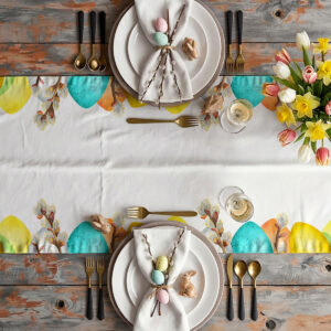 widok z góry na udekorowany stół z bieżnikiem pokazującym rząd turkusowych i żółtych pisanek