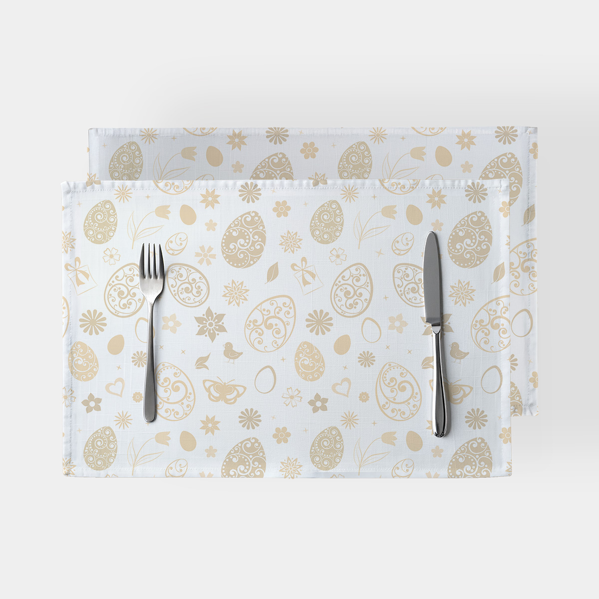 Podkładka z kremowymi ozdobnymi jajkami i kwiatowym wzorem na jasnym tle, widok z góry