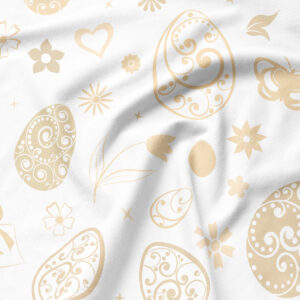 Zbliżenie na delikatny druk kremowych wzorów jajek, kwiatów i ornamentów na tkaninie