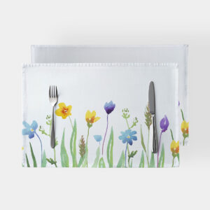 Podkładka ze wzorem akwarelowej łąki ułożona na stole z widocznymi sztućcami